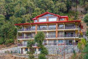 um grande edifício ao lado de uma montanha em Golden Bliss Cottage by VEO - Part of StayVista em Rāmgarh