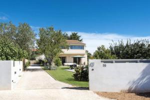 dom z białym płotem przed podjazdem w obiekcie Sunny Summer House 4* w Rovinj