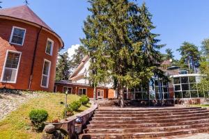 una casa con un árbol y escaleras delante en Дивный Мир Хижина, en Baranovo