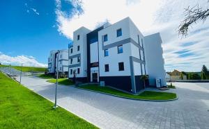 a large white building on the side of a street at Apartamenty na Wzgórzu in Bochnia