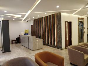 eine Lobby mit Stühlen und Tischen in einem Gebäude in der Unterkunft Hotel Zakaria International in Dhaka