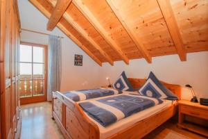 ein Schlafzimmer mit einem großen Bett und einer Holzdecke in der Unterkunft Holzleitnerhof in Traunstein