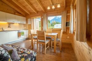 a kitchen and dining room with a table and chairs at Mountain-Chalets Sonnenberg in Nüziders