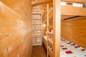 a log cabin bedroom with two bunk beds at Mountain-Chalets Sonnenberg in Nüziders