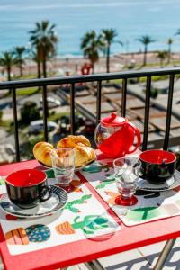 a table with cups and plates of food on a balcony at TAMARIS AP4206 By Riviera Holiday Homes in Nice
