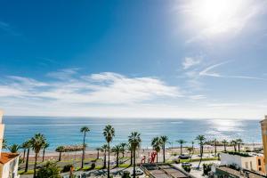 a view of a beach with palm trees and the ocean at TAMARIS AP4206 By Riviera Holiday Homes in Nice
