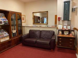 a living room with a leather couch and a mirror at Villager Hotel, Ingoldmells in Ingoldmells