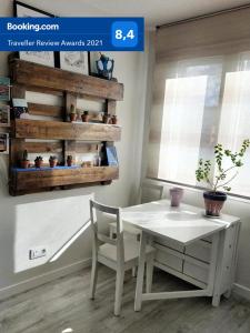 einen weißen Tisch und Stuhl in einem Zimmer mit Fenster in der Unterkunft Ideal Familias, Prime, Netflix y Hbo in Aranjuez