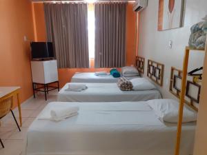 a room with two beds and a television in it at Hotel Itaipu in Goiânia