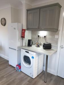 una cucina con lavatrice e frigorifero di 5beds-2WC-2shwr-secure 2 van off-road-Biz WiFi-washer-dryer a Corby