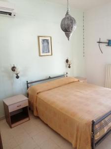 ein Schlafzimmer mit einem großen Bett und einer Lampe in der Unterkunft Casa Christina in Galatone