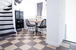 a dining room with a table and chairs on a checkered floor at Puur Mechelen in Mechelen