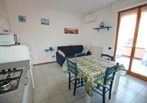 una cucina con tavolo e sedie e una cucina con piano cottura di LE MAREE EMATITE a Porto Azzurro