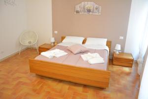 una camera da letto con un letto e due asciugamani di La Casa di LEO - Apartments a Recanati