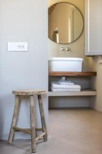 a stool next to a bathroom with a mirror at Casale Tre Gelsi in Cingoli