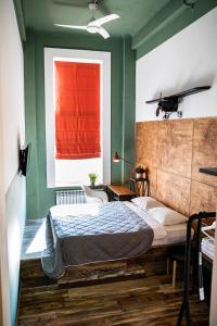 Schlafzimmer mit einem Bett und einem roten Fenster in der Unterkunft Fabrika Hotel in Rostow am Don