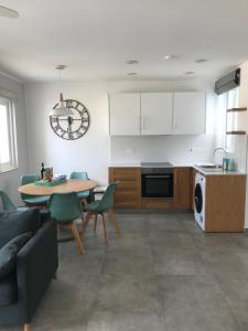 cocina y sala de estar con mesa y sillas en The Three Trees Apartments en Sliema
