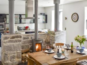 cocina con mesa de madera y chimenea en Ballyquirke House en Moycullen