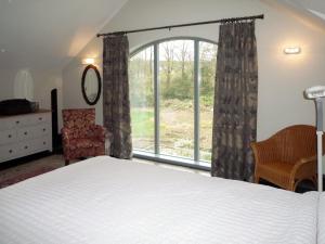 1 dormitorio con cama y ventana grande en Ballyquirke House en Moycullen