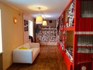 a living room with a white couch and a red shelf at Zhit Prosto Hostel in Pyatigorsk