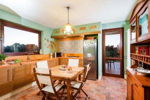 a kitchen with a wooden table and chairs in it at Villa Laura in Marsala