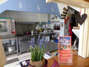 a kitchen with a table with purple flowers in it at Auberge de Trente Pas in Saint-Ferréol-Trente-Pas