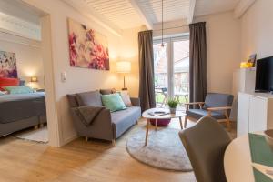 a living room with a couch and a bed at Weberhof Ferienapartments in Rostrup am Westufer des Zwischenahner Meers in Bad Zwischenahn