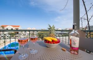 a table with two glasses of wine and a bowl of fruit at Lotus Hotel Apartments in Kato Daratso