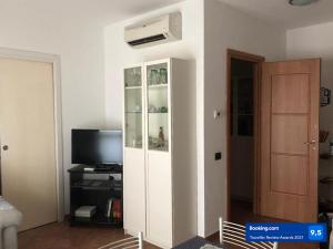 a living room with a white cabinet and a television at Gaia house in Milan