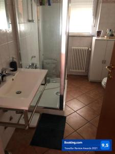uma casa de banho com um chuveiro, um lavatório e uma mesa em Gaia house em Milão
