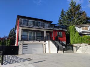 een huis met een garage en een rood huis bij Modern & Luxurious Suites in Surrey in Surrey