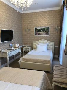 a hotel room with two beds and a television at Hotel Ekaterina Kostroma in Kostroma