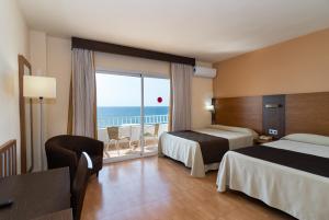 a hotel room with two beds and a view of the ocean at Rincón Sol in Rincón de la Victoria