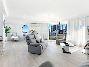 a living room with a couch and a chair at Acapulco 2 Bedroom Ocean View Surfers Paradise in Gold Coast