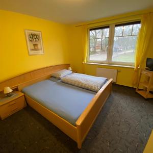 ein Schlafzimmer mit einem Bett in einem gelben Zimmer in der Unterkunft Ferienhof Möller 