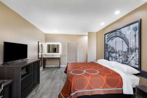 Cette chambre comprend un lit et une télévision à écran plat. dans l'établissement Super 8 by Wyndham Houston NW Beltway 8-West Rd, à Houston