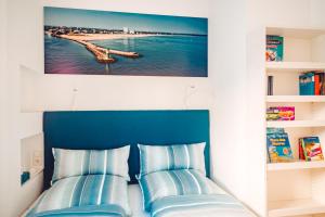 a bed with two blue pillows in a bedroom at Ferienwohnung Windspiel in Warnemünde