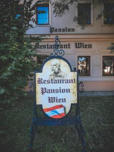 a sign in front of a building in front of a building at Restaurant Pansion Wien in Čierny Brod