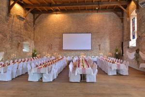 a large banquet hall with white tables and chairs at Schloß Altenhausen in Altenhausen