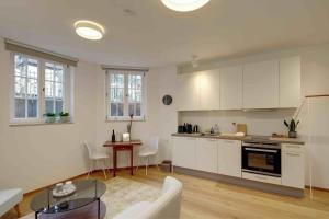 a kitchen with white cabinets and a table at Boutique Apartments Freiburg - Eva in Freiburg im Breisgau