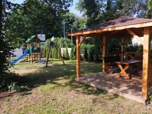 a wooden gazebo with a playground in a park at Hotel Zakliki in Krakow