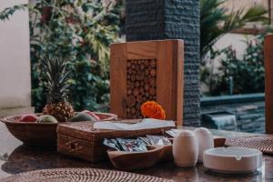 a table with baskets of fruit and a bowl of pineapple at AB UBUD LUXURY VILLA in Ubud