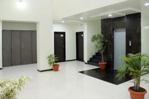 a lobby with potted plants and black doors at HOTEL NEW BHARTI in Aurangabad