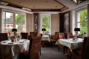 ein Restaurant mit 2 Tischen, Stühlen und Fenstern in der Unterkunft Hotel Zur Linde in Schermbeck