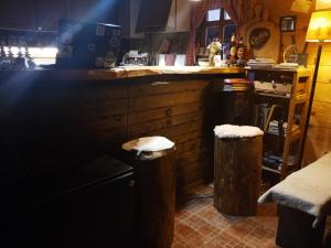 a kitchen with a counter and two stools at Planinski dom "Tornik" Zlatibor in Ribnica