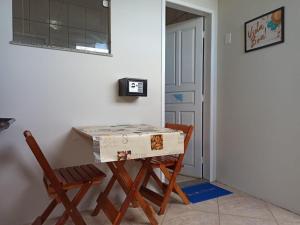 une table avec une boîte placée à côté d'une chaise dans l'établissement Flats Aconchego com Ar condicionado, à Rio das Ostras