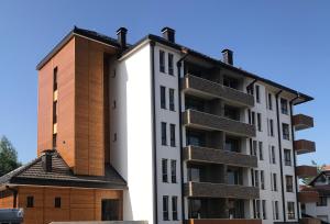 un edificio alto blanco con un marrón en Apartman 23 - Vila Harizma en Zlatibor