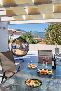 uma mesa com dois pratos de comida e taças de vinho em Iria's Luxury Apartments em Limenaria