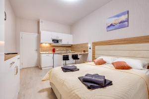 1 dormitorio con 1 cama grande y 2 toallas. en Apart 21 (Salut-11 Group), en San Petersburgo