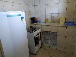 uma cozinha com um fogão e um frigorífico branco em Flats Aconchego com Ar condicionado em Rio das Ostras